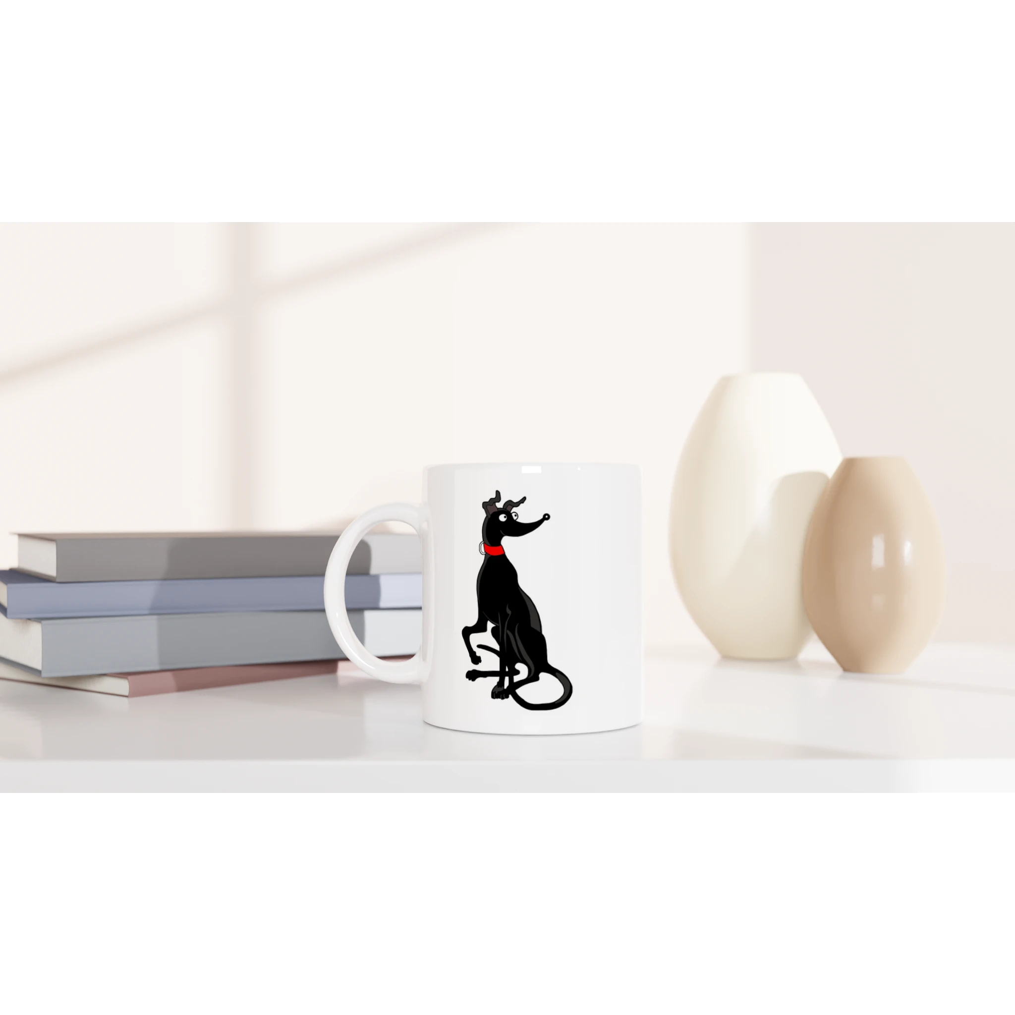 White ceramic mug with black greyhound illustration styled on a tabletop with books and vases