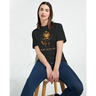Woman sitting on a stool wearing a black T-shirt with orange cat illustration and Play with Me text