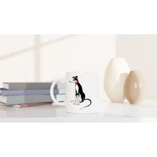 White ceramic mug with black and white greyhound illustration on a tabletop beside books and vases